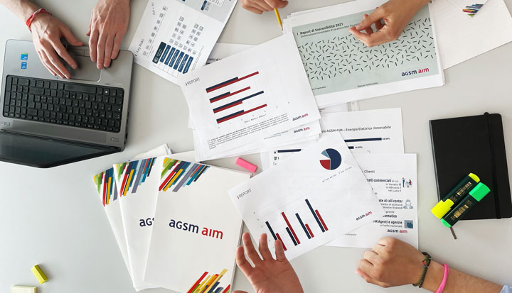 Tavolo di lavoro con grafici e depliant agsm aim